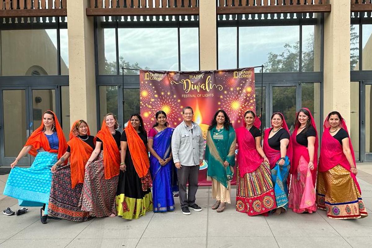 people lined up in front of Diwali backdrop