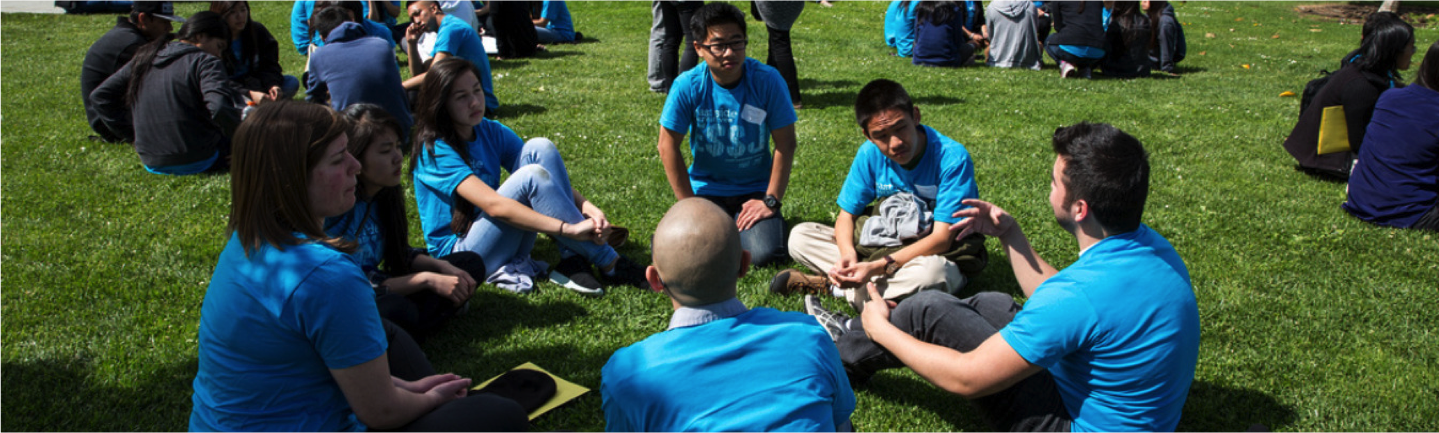 students sitting and talking on lawn