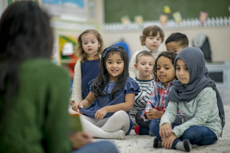 young children seated in front of teacher