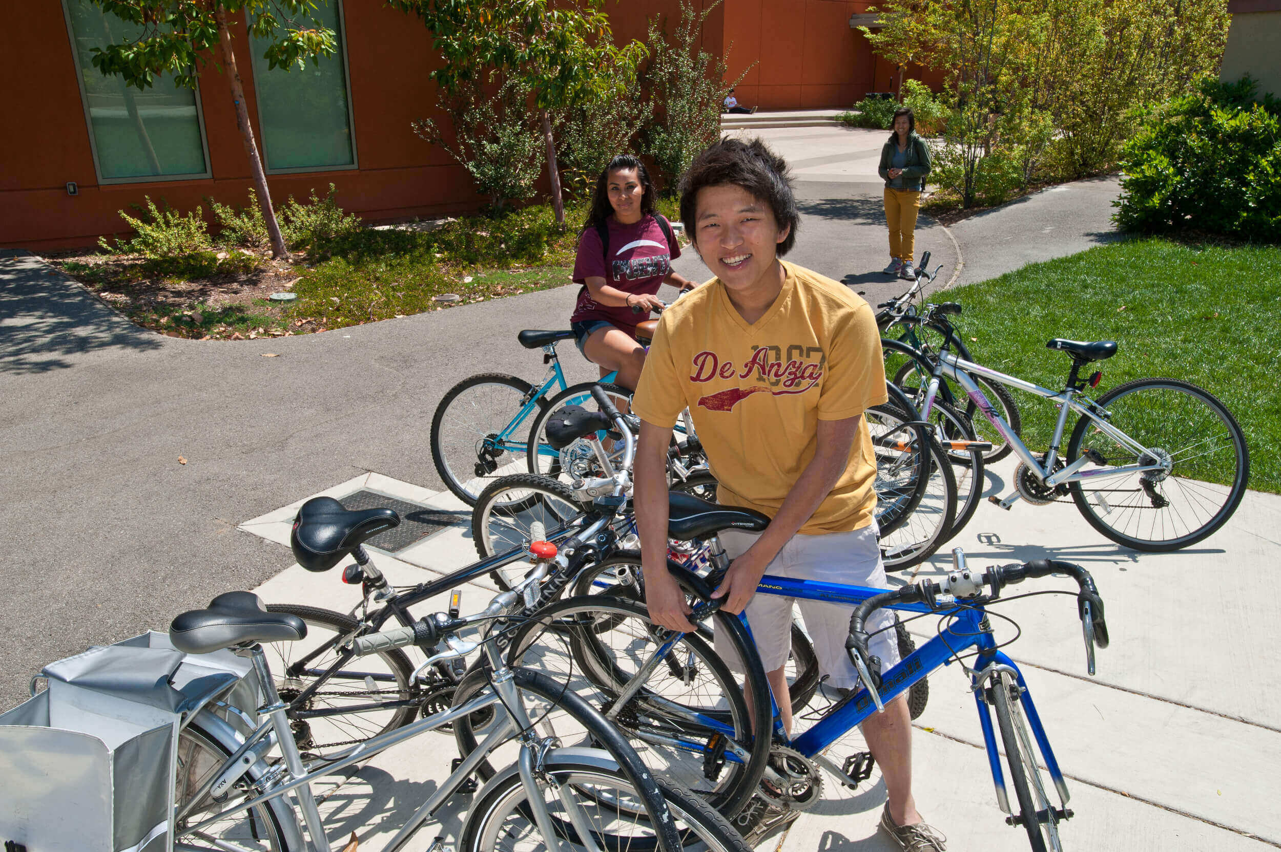student with bicycle at rack