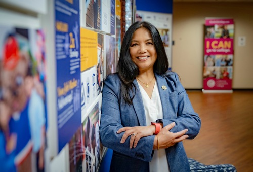 Rowena standing in room full of posters facing camera