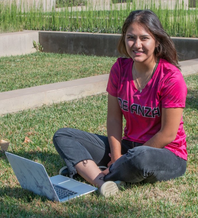 young woman sitting outside with laptop