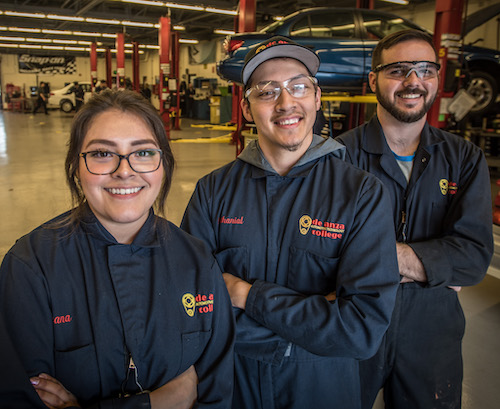 young woman and two young men in auto tech coveralls
