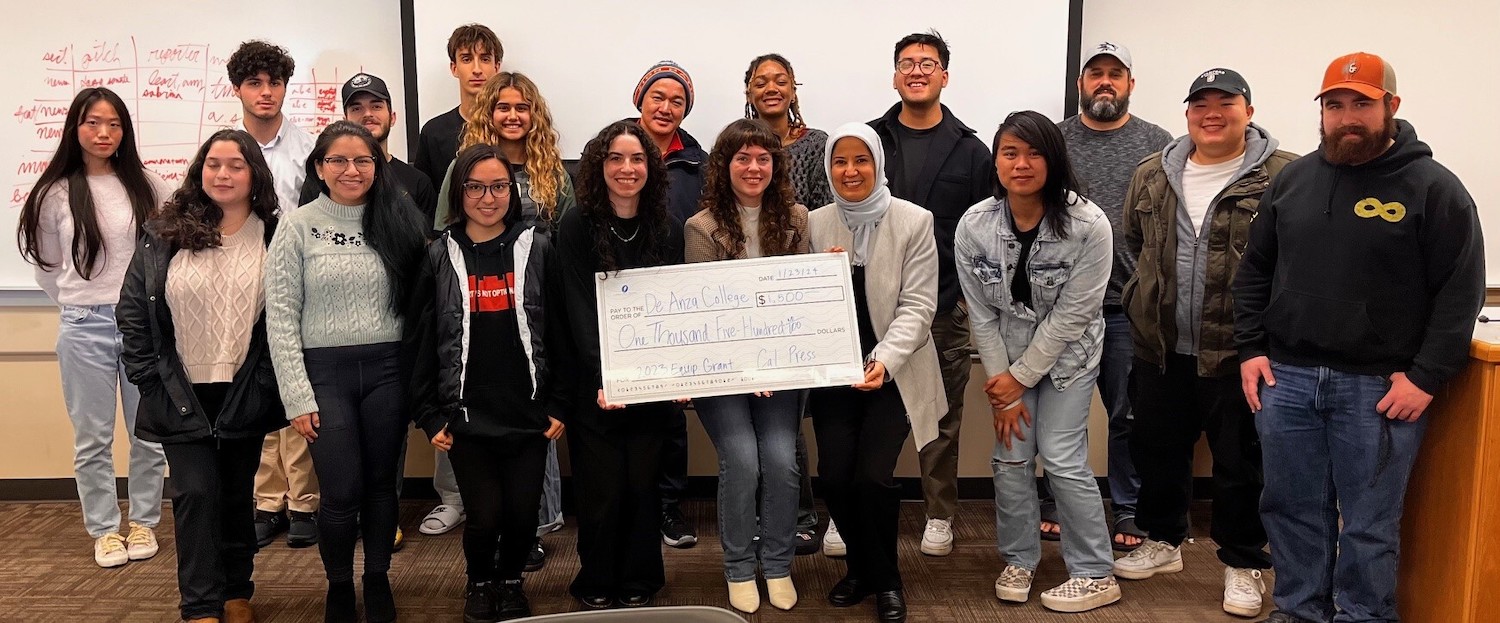 student news staffers with enlarged check