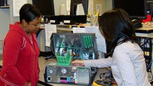 Two student interns working on computer board