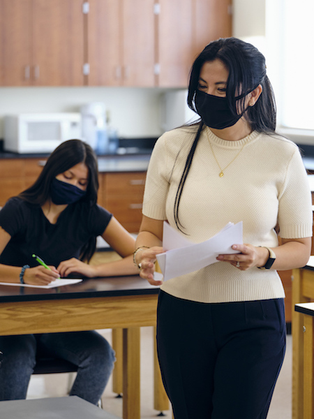 teacher with student, both wearing masks