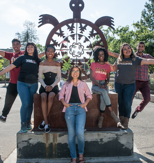 students standing around turtle sculpture