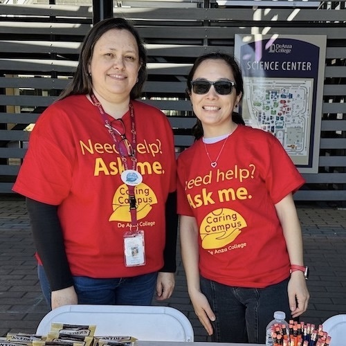 two women in red Caring Campus shirts