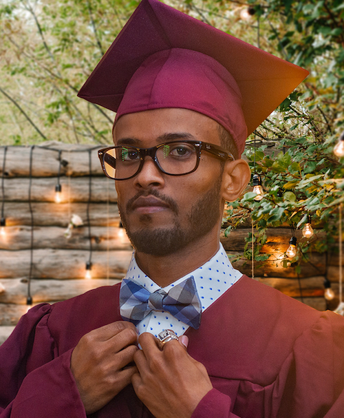 serious young man in grad cap adjusting bow tie