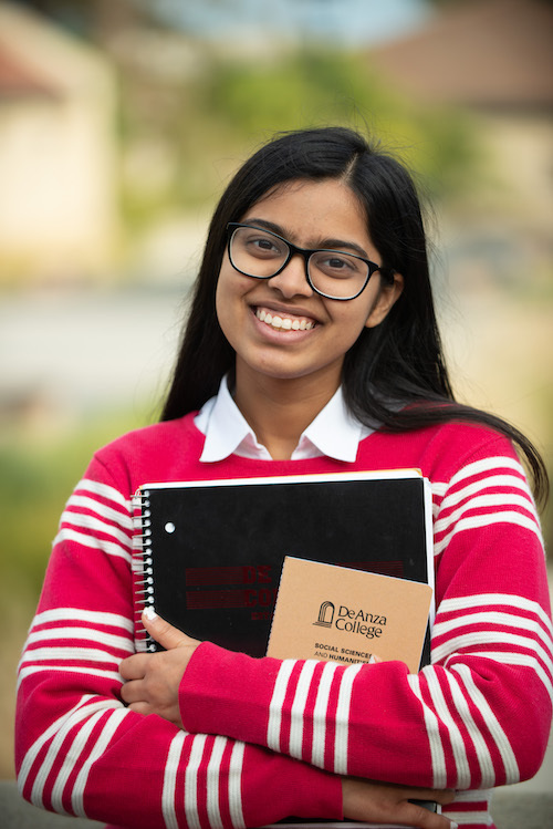 young woman in red sweater with De Anza notebook