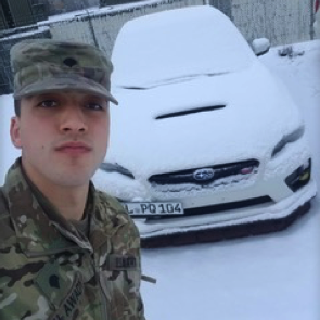 Alwady in military fatigues in front of car covered in snow
