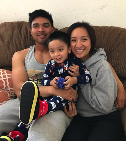 young man on couch with young woman and little boy, smiling