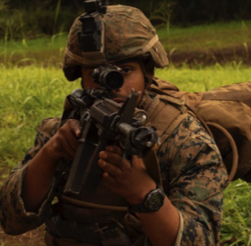 man in military gear and helmet aiming rifle