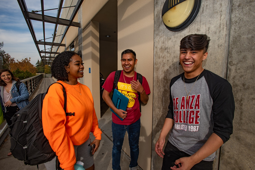 three students laughing outside science building